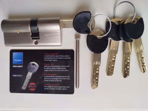 Bombín Tesa de perfil europeo junto a llave anticopia Bombín Tesa de perfil europeo con llave anticopia instalado por cerrajero de Reparhogar